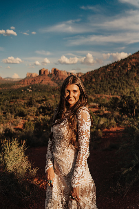 Bride poses in front of peaks before her Sedona Elopement ceremony