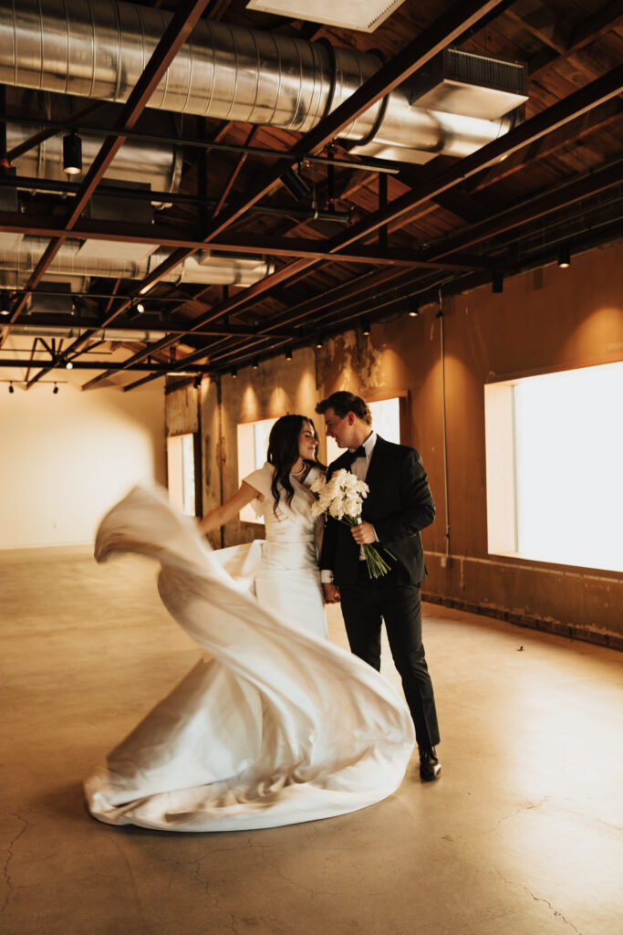 Bride twirls her dress in the warehouse ballroom of The Abbey on Monroe.