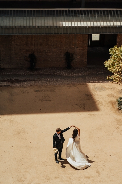 Groom spins bride in the courtyard of The Abbey on Monroe wedding venue